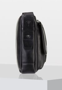Borsa in pelle nera con forma rettangolare, texture liscia e patta. Presenta una toppa con logo e una chiusura a scatto in metallo.