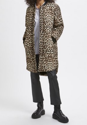 Luipaardprint jas met een relaxte pasvorm, voorzien van twee zijzakken, zwarte ribgebreide manchetten en een knoopsluiting. Draag het over een licht shirt en een broek.