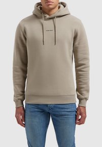 Beige hoodie met een trekkoord, ribgebreide manchetten en zoom. In het midden bevindt zich het 'PURE PATH' logo in een contrasterende kleur. Zachte textuur van de stof.
