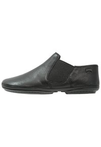 Zapato negro tipo slip-on hecho de cuero, con paneles laterales elásticos y un acabado suave. Perfil bajo con punta redondeada y suela flexible.