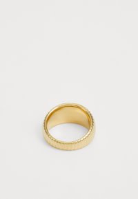 Wide gold band ring with subtle ridged texture displayed on a plain white background.