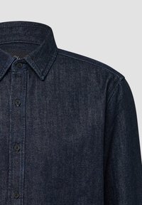 Camicia di denim scuro con colletto button-down, caratterizzata da cinque bottoni sul davanti, una sottile texture e cuciture a contrasto lungo le cuciture.