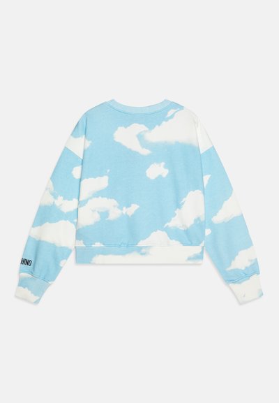 Lyseblå kort sweatshirt med et hvitt sky-mønster, ribbestrikkede mansjetter og hals, med svart tekstdetalj på ermet.