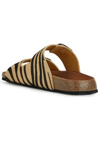 Sandale à brides avec un motif rayé tigre tan et noir, présentant un design ouvert, un matériau texturé et une semelle en liège avec des accents noirs.