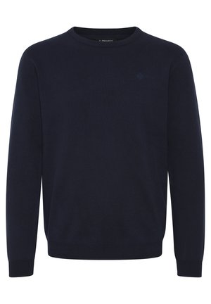 Tumesinine ringsuurte särk, mis on valmistatud tekstuurilisest kudumiskangast, ribikattega varrukate ja alläärme ning diskreetse logoga rinnal.