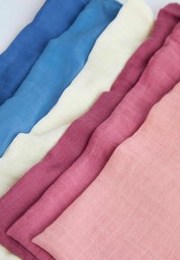 Set van vijf stukken katoen in tinten blauw, crème, roze en bordeaux, met een zachte, gestructureerde oppervlakte en subtiele patronen.