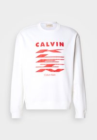 Felpa bianca con testo grafico rosso "CALVIN" e forme astratte. Polsini e orlo a coste, design casual, tessuto morbido.