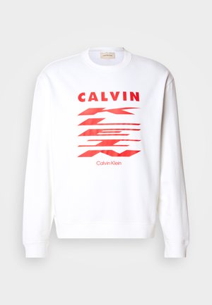 White sweatshirt featuring red graphic text "CALVIN" and abstract shapes. Ribbed cuffs and hem, casual design, soft fabric.