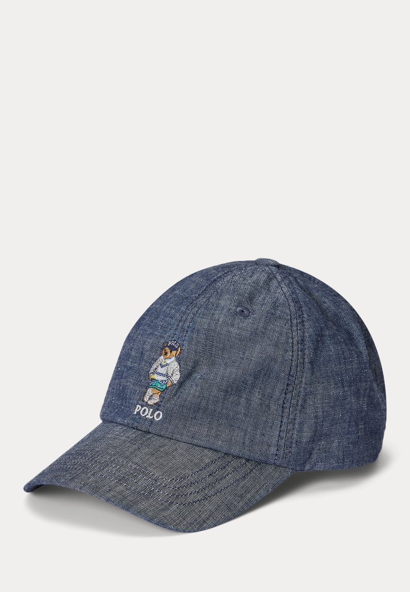 Boné de beisebol em denim com um design bordado de um urso na frente em branco, azul e verde, juntamente com a palavra "POLO".