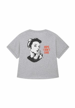 T-shirt di cotone grigio con una grafica nera di una donna con un foulard e il testo "OOPS I DON'T CARE" in arancione bold. Maniche corte, vestibilità rilassata.