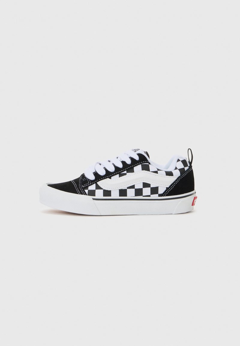 Svart och vit rutiga canvas sneakers med vita snören, gummisulor och vadderad krage. Har logotypdetaljer och kontrasterande textur.