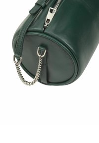Borsa rotonda verde in pelle con chiusura a zip, accentuata da una catena in argento e due attacchi in pelle alla base. Texture liscia.