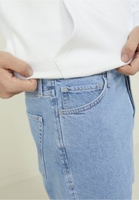 Ljust blå denimjeans med rak passform, som har två framfickor, en liten MYNTficka och synliga sömmar.