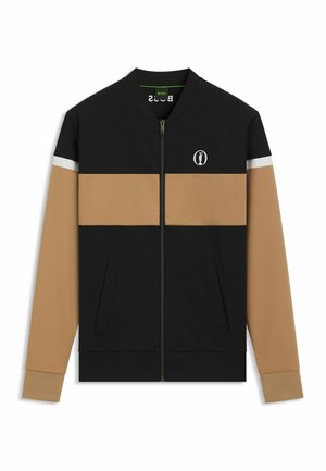 Black and tan zip-up jacket with a grid pattern, white accent stripe, ribbed cuffs, and logo detail on the chest. Contains side pockets.