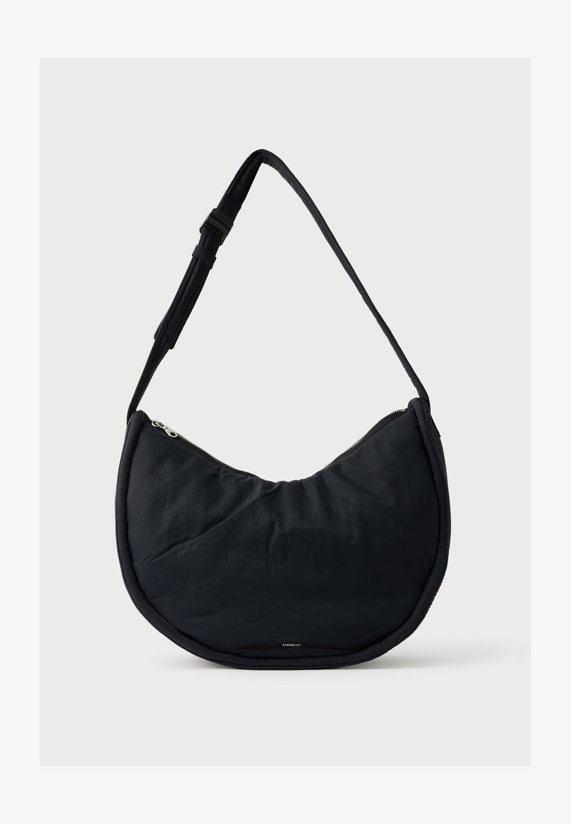 Musta olkalaukku, jossa on kaareva muoto, valmistettu pehmeästä nylonista, varustettu vetoketjullisella suljinnalla ja säädettävällä hihnalla, suunniteltu helppoa kantamista varten.