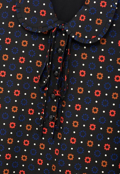 Czarna tkanina w białe kropki z florystycznymi wzorami w kolorze czerwonym, niebieskim i brązowym. Posiada kołnierzyk i zapięcie na guziki z wiązaniami.