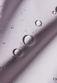 Texturiertes Gewebe in sanftem Lavendel mit unterschiedlichen Größen von Wassertropfen auf der Oberfläche, das ein glattes Finish und einen subtilen Glanz hervorhebt.