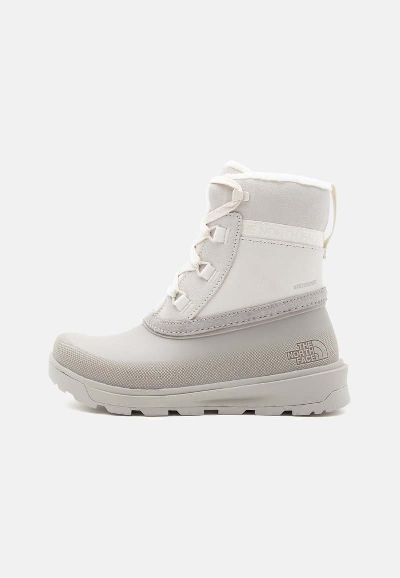 Grijze waterdichte boots met een getextureerde rubberen zool, een gepadded stoffen bovenzijde en witte veters. Heeft het The North Face-logo aan de zijkant.