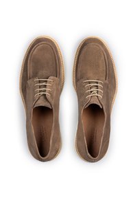 Scarpe di camoscio marrone con punta arrotondata, lacci beige e suola cucita a contrasto. Fodera interna liscia e branding sottile all'interno.