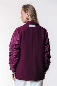 Long-sleeved jacket featuring a burgundy fabric body with satin puffed sleeves, white striped cuffs, and a label on the back.