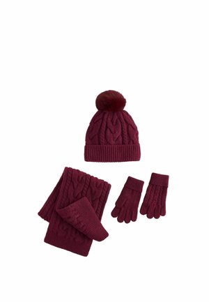 Burgundy knitted winter set with pom-pom hat, scarf, and gloves featuring a cable knit pattern.