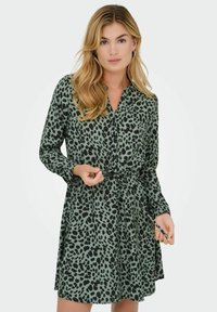 Roheline mustritega särk-kleit mustade leopardilaikude ja nööpide esiosaga, pikkade käistega ning sidumisega vöö detailiga. Sile kangas.