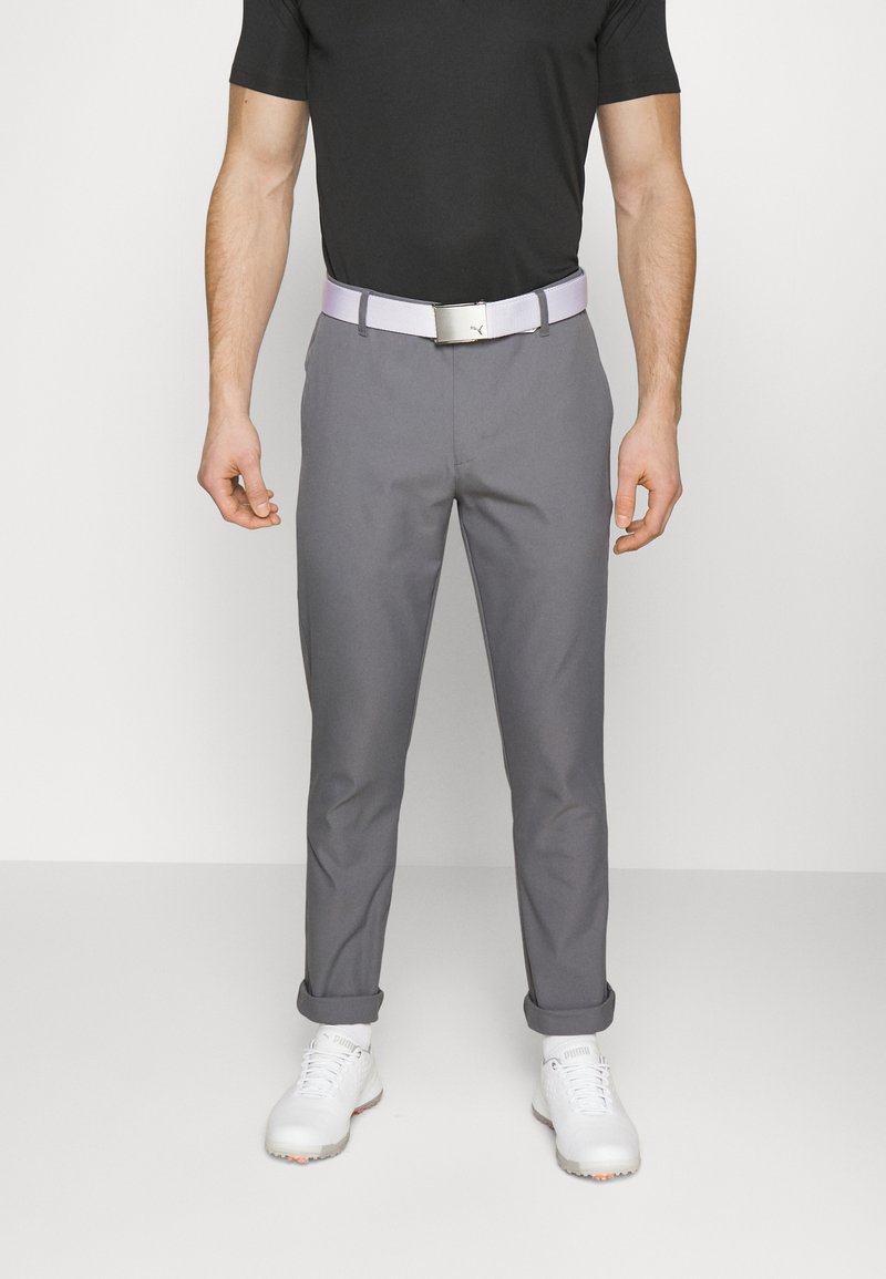 Gray golf pants with a slim fit, cuffed ankles, and a textured surface. Paired with a light-colored belt and white golf shoes.
