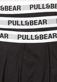 Crne pamučne bokserice s bijelim elastičnim pojasom na kojem se nalazi logo "PULL&BEAR". Glatka tekstura, prilagođenog dizajna, tri para složena.