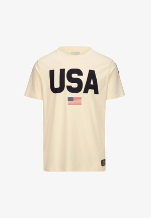 T-shirt di cotone color crema con una grande scritta nera "USA" e una piccola grafica della bandiera americana. Maniche corte, scollatura rotonda.