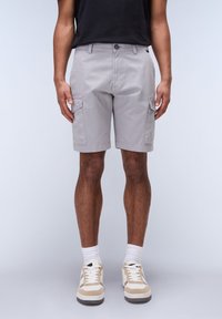Lysegrå cargoshorts med sidelommer, knaplukning og lige pasform. Iført med beige- og hvide sneakers og hvide sokker.