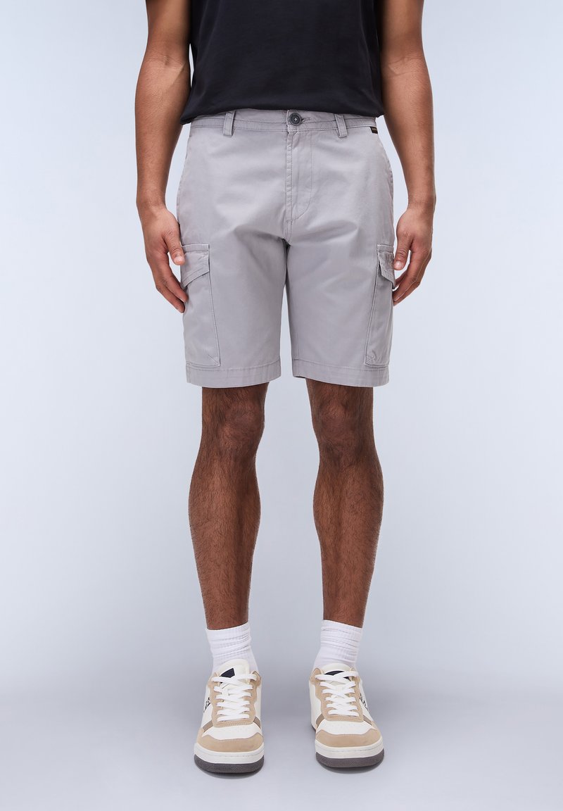 Lysegrå cargoshorts med sidelommer, knaplukning og lige pasform. Iført med beige- og hvide sneakers og hvide sokker.