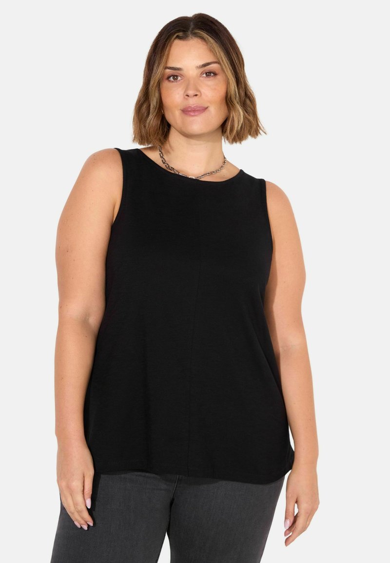 Schwarzes ärmelloses Oberteil mit rundem Ausschnitt und weichem, fallendem Stoff; kombiniert mit grauen Jeans, minimalistisches Design und keine sichtbaren Muster oder Akzente.