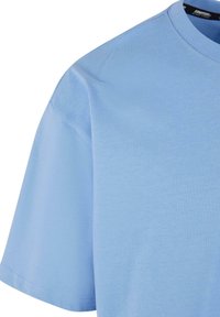 Light blue cotton t-shirt featuring a crew neckline and short sleeves, with smooth texture and no visible patterns or embellishments.