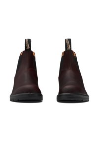 Botas Chelsea de cuero burdeos con paneles laterales elásticos y suela de goma negra. Con una lengüeta en el talón para ponerlas fácilmente.