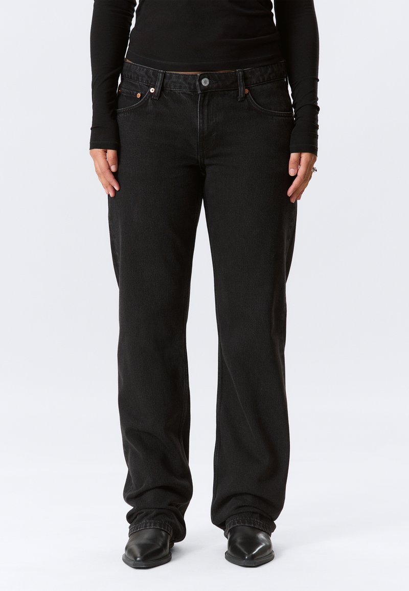 Jeans in denim nero con una vestibilità rilassata, design a cinque tasche e dettagli in metallo. Il materiale testurizzato offre una resistenza durevole.