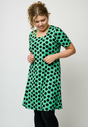 Grünes Kleid mit einem geometrischen schwarz-weißen Muster, kurzen Ärmeln und einem quadratischen Ausschnitt. Hergestellt aus glattem Stoff, verbesserte Designelemente.