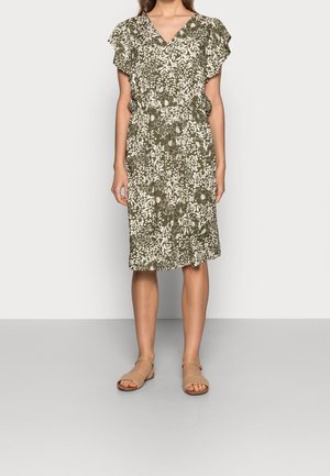 Olijfgroene jurk met wit bloemenpatroon, V-vormige halslijn, ruches mouwen en een nauwsluitende taille, gecombineerd met tan sandalen.