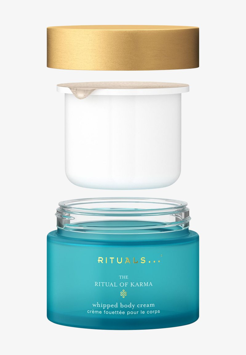 En genomskinlig turkos burk med ett guldmetallock visar en vit kräm inuti. Texten på burken inkluderar "RITUALS", "RITUAL OF KARMA" och "vispad kroppskräm."