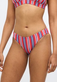 Piros-fehér csíkos bikini alsó kék díszítésekkel; sima textúrájú, alacsony derekú, közepes takarással.