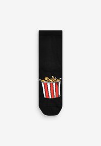 Sorte sokker med et design af en farverig popcornbøtte med røde og hvide striber samt gule popcorndetaljer på siden.
