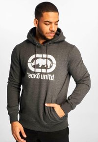 Sweat à capuche gris foncé en matériau doux, présentant un grand graphisme blanc d'un rhinocéros et le texte "eckō unltd." sur le devant.