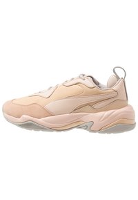 Chaussure de sport rose clair en suède et mesh, dotée d'une semelle amortissante et d'une languette à l'arrière.