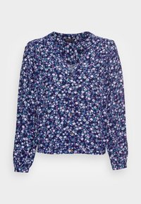 Marineblaue Bluse mit langen Ärmeln, V-Ausschnitt und Knopfdetails. Sie hat ein Muster aus weißen und rosa Blumen auf einem dunklen Hintergrund.