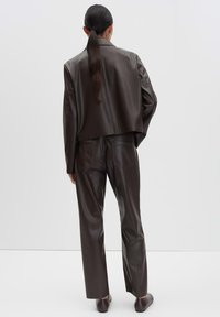 Dunkelbraune Kunstlederjacke und passende Hose, glatte Textur, leicht cropped Jacke, gerade geschnittene Hose mit Gesäßtaschen, elegantes Design.