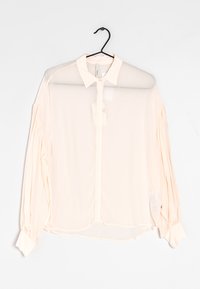 Blusa leggera rosa chiaro, trasparente, con chiusura a bottoni, colletto appuntito e maniche lunghe a sbuffo, caratterizzata da dettagli arricciati sulle maniche.