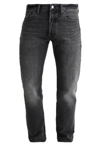 Vaqueros de mezclilla oscura con corte entallado, acabado desgastado, diseño de cinco bolsillos y cierre con botón metálico en la cintura.