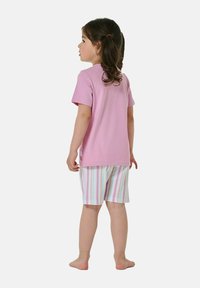 Hellrosa T-Shirt mit kurzen Ärmeln, kombiniert mit gestreiften Shorts in Pastellfarben. Der Stoff wirkt weich, lässig und eignet sich gut für warmes Wetter.