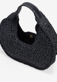Bolso negro tejido con forma curva, hecho de material similar a la paja. Cuenta con un asa de cuero y un cierre magnético.