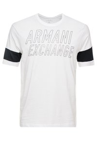 Bílá bavlněná tričko s nápisem "ARMANI EXCHANGE" v tučném černém písmu, se černými akcenty na rukávech pro zvýšení kontrastu.
