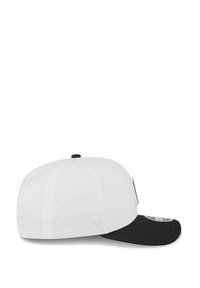 White cap with black visor, featuring perforated design on the crown. Snapback closure and flat brim with a logo patch on the side.